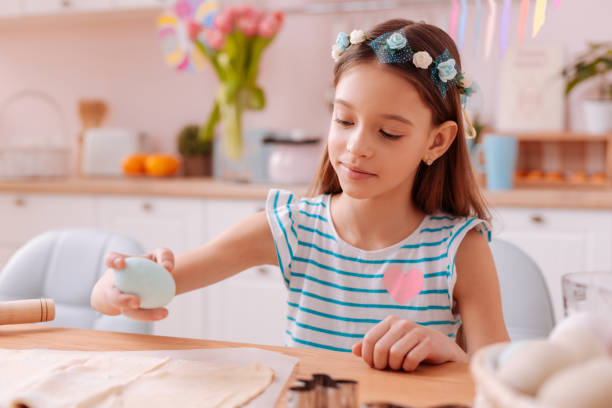 Cute little female working with pastry in the kitchen