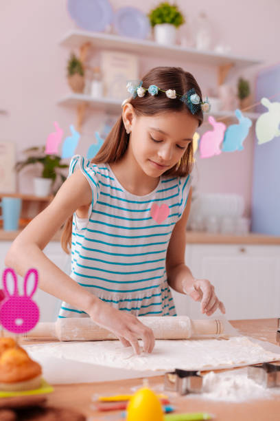 Cute brunette kid forming cookies from dough