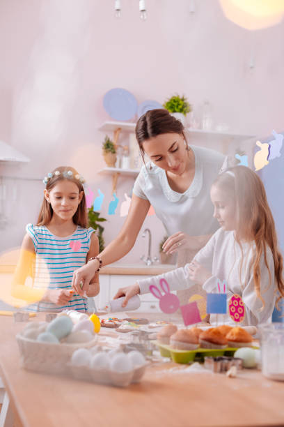 istock Kind longhaired girls helping their mother with baking 1136860497