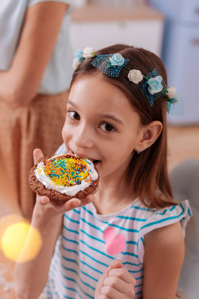 istock Close up of pretty kid that trying cookie 1136860513