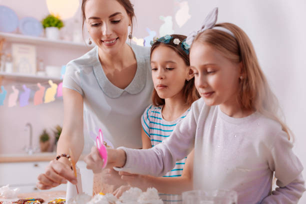 istock Friendly girls putting decor on tasty cakes 1136860520