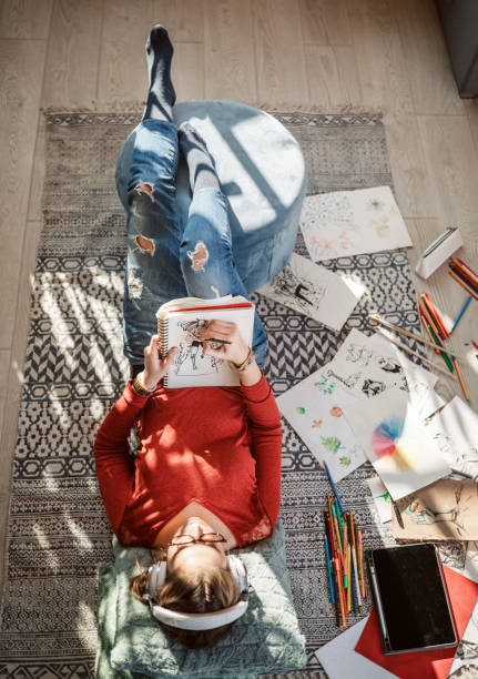 Young Female Artist At Home, Creative Atmosphere, Lying Down On The Floor, Relaxing And Drawing