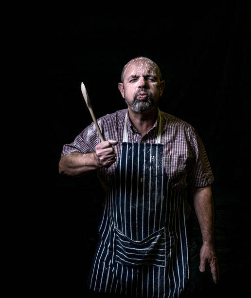 istock chef with apron and wooden spoon 1136860695