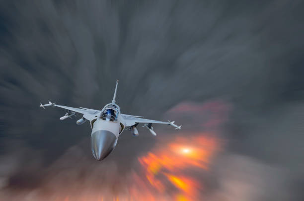 istock Military fighter flying at high speed amid smoke and explosion. 1136861564