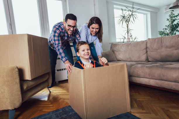 istock Happy family moving home with boxes around, and having fun. 1136864228