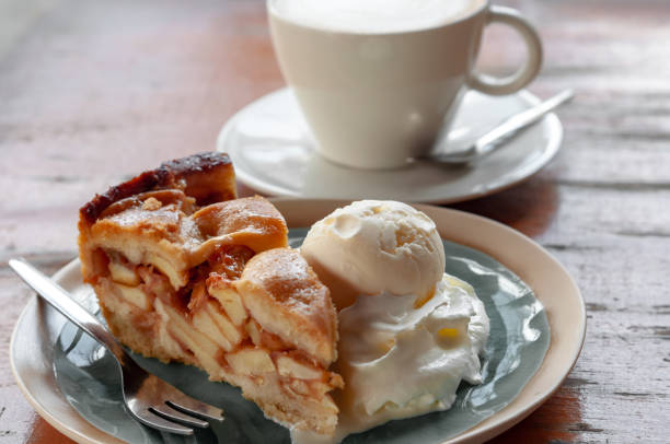 Apple Pie with Ice Cream and Whipped Cream Slice of apple pie with scoop of vanilla ice cream and whipped cream and cappuccino in the background apple pie stock pictures, royalty-free photos & images