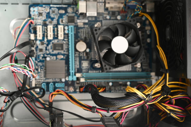 view into an open computer, desktop pc tower with motherboard, cooler and cables, selected focus, narrow depth of field