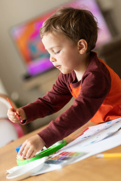 istock Three years old child painting with watercolors 1136868841