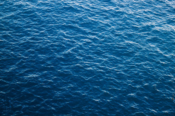 Blue sea water background, Atlantic Blue sea with ribbed textured waves, top view. Mediterranean Sea in Italy, copy space sea stock pictures, royalty-free photos & images