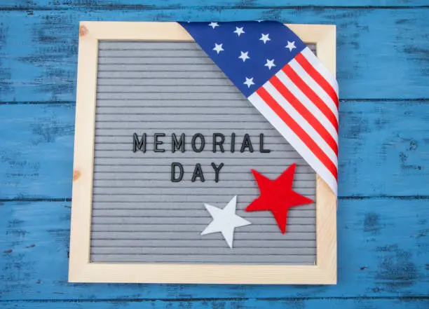 Frame with inscription Memorial Day on a blue wooden table