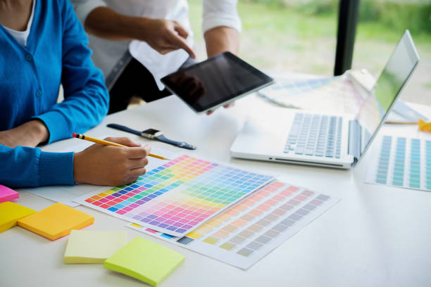 istock Graphic design and color swatches and pens on a desk. Architectural drawing with work tools and accessories. 1136870528