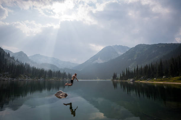 istock Taking the plunge in a mountain lake 1136870619