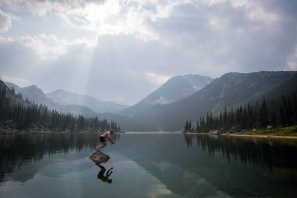 istock Taking the plunge in a mountain lake 1136870623