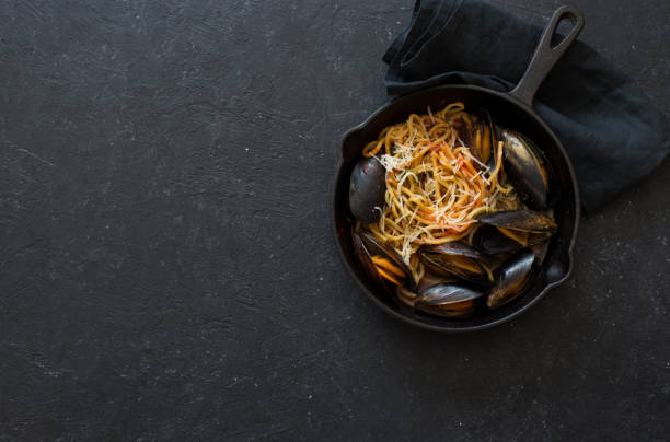 Spaghetti and mussels in an iron pan