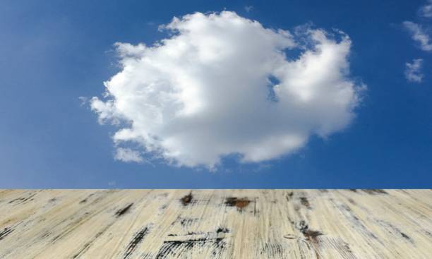 istock old painted washed oak wooden table on the blue sky clouds background, wood table 1136873633