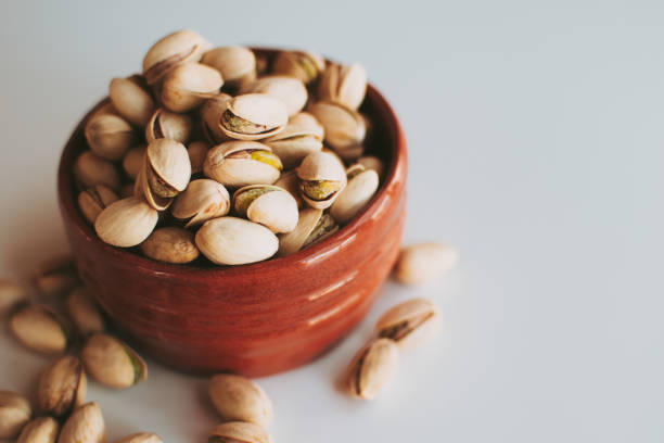 Handful of pistachios in a brown vase.