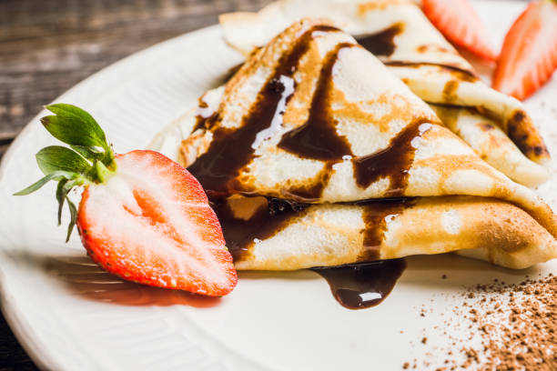 istock Russian thin pancakes (blini), with strawberry and chocolate sauce 1136881760