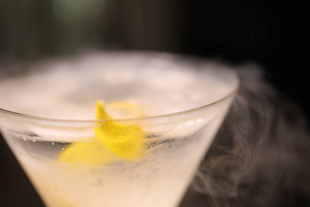 A Macro View Of A Handcrafted Dry Ice Martini Garnished With A Fresh Lemon Twist