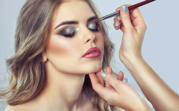 istock Makeup artist makes smoky eyes makeup. Applying make-up and face care. 1136885011