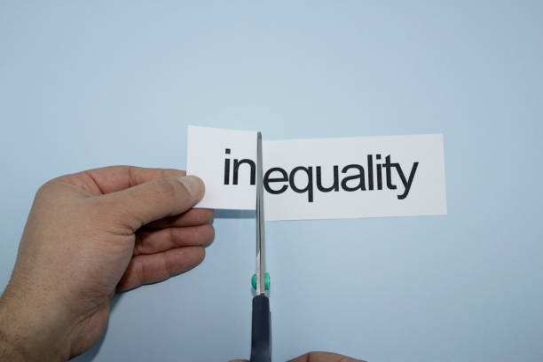 istock equality and inequality.Hand cutting paper with scissors 1136885873