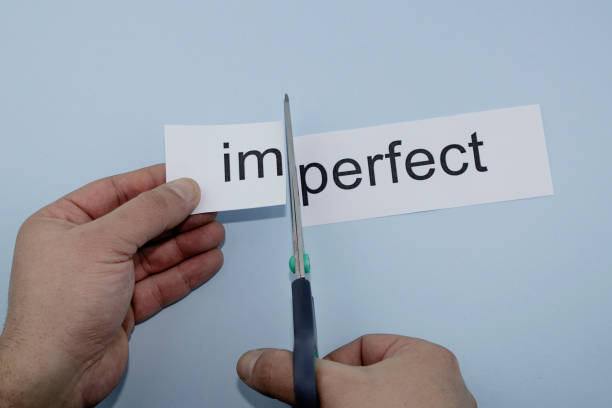 istock perfect and imperfect.Hand cutting paper with scissors 1136885998
