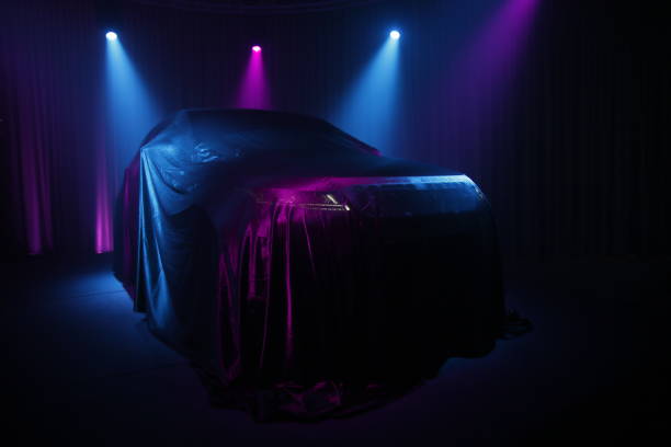 istock Car covered with dark cloth on a black background 1136888991