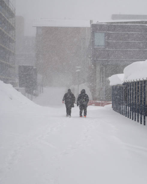istock Blurred people walking in a snow storm 1136893590
