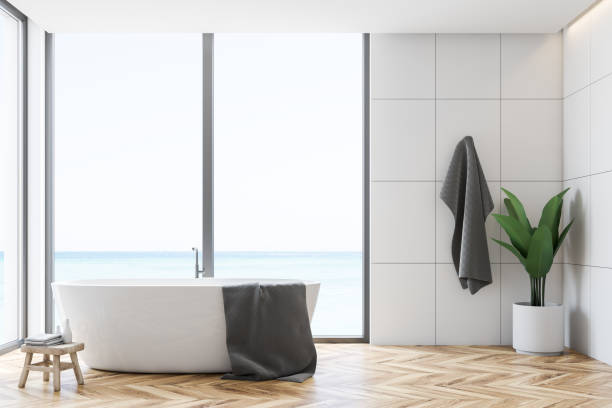 istock White tile bathroom interior, tub and towel 1136895284