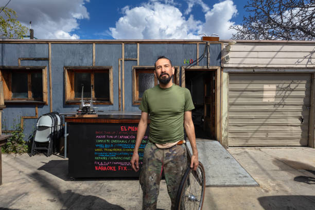 istock Bicycle Mechanic Outside Shop on Sunny Day 1136896389