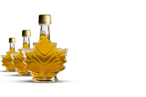 istock Canadian maple syrup in three transparent bottles with leaf shape isolated on white background 1136896473