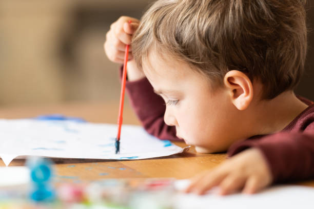 istock Three years old child painting with watercolors 1136897951