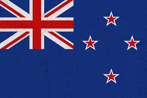 New Zealand flag on concrete wall. Patriotic grunge background. National flag of New Zealand