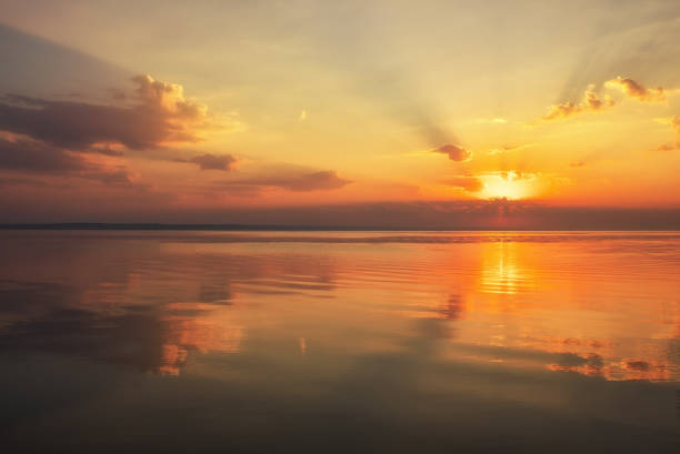 istock Dramatic sunset sky with clouds over lake. Composition of nature 1136898238