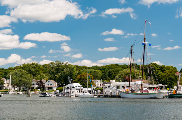View of the Mystic Seaport with boats and houses, Connecticut Mystic Seaport, is an outdoor recreated 19th century village and educational maritime museum. Visitors will find a lighthouse replica of Brant Point Light. whaling stock pictures, royalty-free photos & images