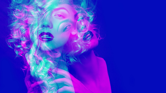 Portrait of a attractive woman with blonde curly hair. Double color exposure.
