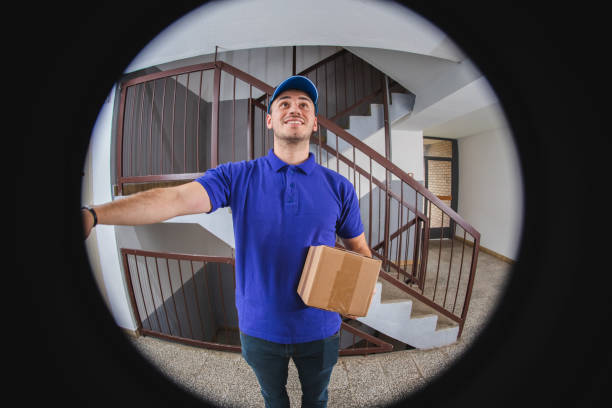 istock Postman at the door viewed through a spy hole 1136900850