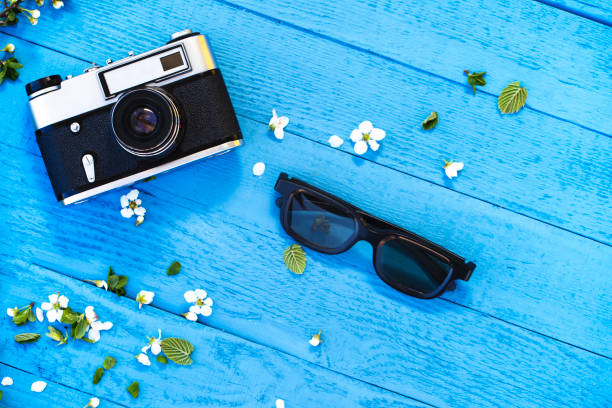 istock analog camera and sunglasses on blue background 1136901796