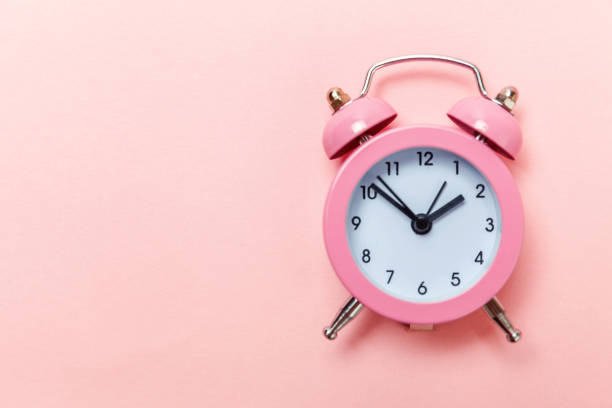istock Vintage alarm clock Isolated on pink pastel background 1136902092