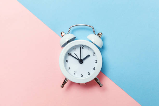 istock Vintage alarm clock Isolated on blue and pink pastel background 1136902139