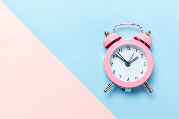 istock Vintage alarm clock Isolated on blue and pink pastel background 1136902143