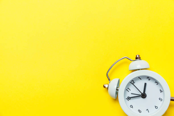 istock Vintage alarm clock Isolated on yellow background 1136902709