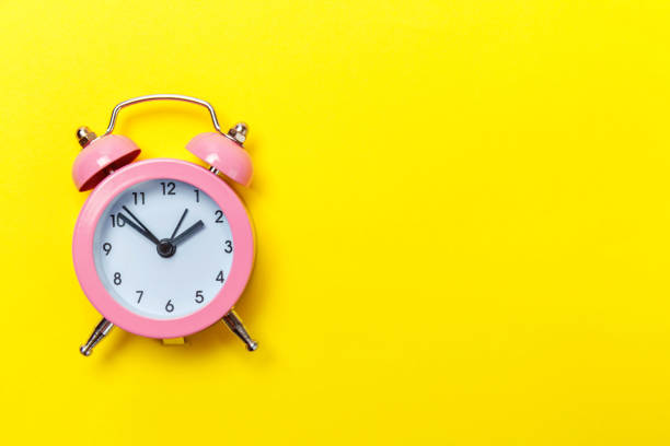istock Vintage alarm clock Isolated on yellow background 1136902729