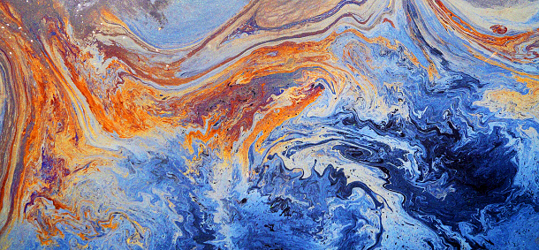 Rainbow colored oil floating on water. Gasoline stains. Colored texture, natural background, panoramic view. Ecological problem. Oil spill. Water pollution
