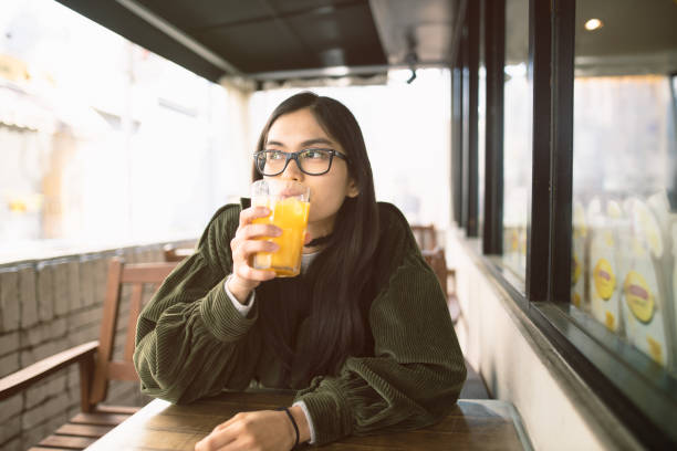 istock Young Asian woman taking a break at open cafe 1136909201