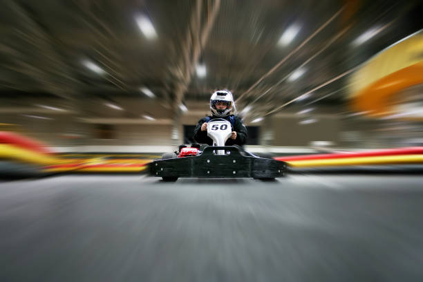 l'uomo con un casco nel go-kart si muove su una pista di karting - motor racing track sports race car motorized sport foto e immagini stock