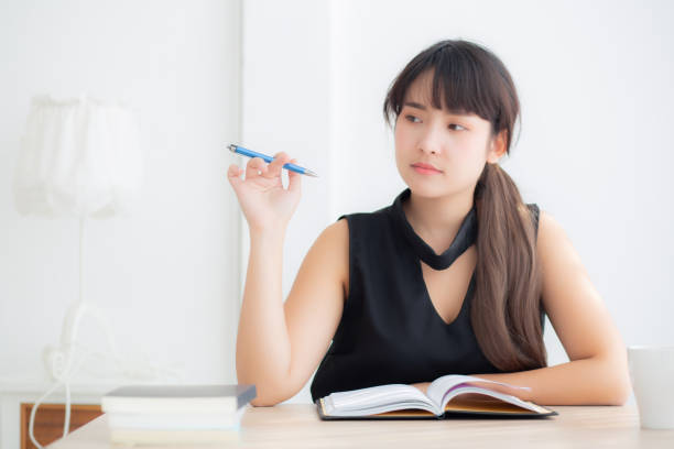 istock Beautiful asian woman writer smiling thinking idea and writing on notebook or diary with happy on desk office, lifestyle of asia girl is success, female planning working, education and business concept. 1136910508