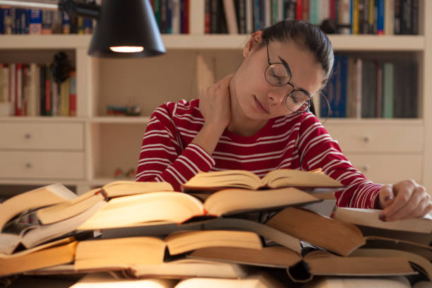 istock beautiful woman reading book at library 1136911314
