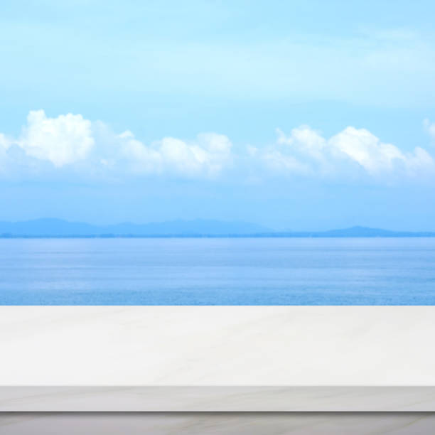 istock Empty white marble table over blur blue sea and sky in summer background, product display montage background, banner 1136913415