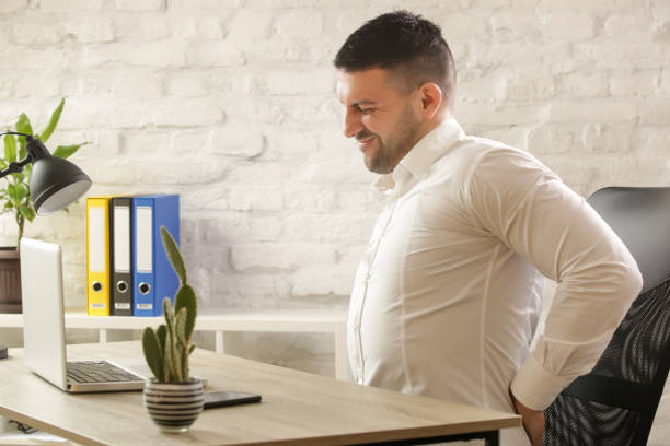 istock Tired young businessman suffering from the backache at office desk after long hours at work 1136913466