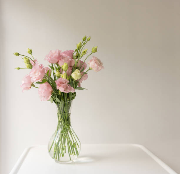 istock Pink lisianthus flowers in glass vase on table 1136915515